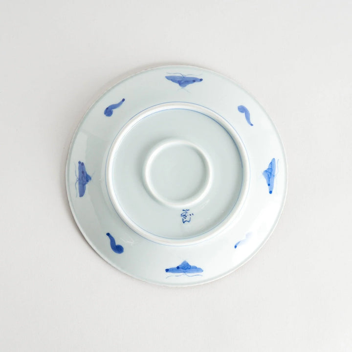 Ceramic plate with intricate blue floral design and bold circular motif framed by copper textured rim.