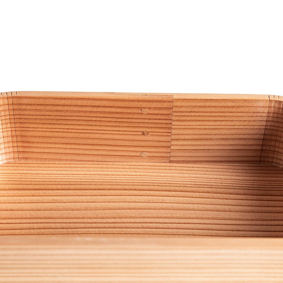 Cedar bento box with lid showing natural wood grain and rounded edges for minimalist Japanese look.
