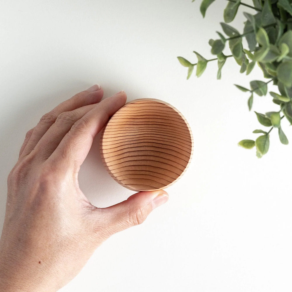 Overhead view of two cedar wood sake cups showcasing their striped texture and smooth finish.