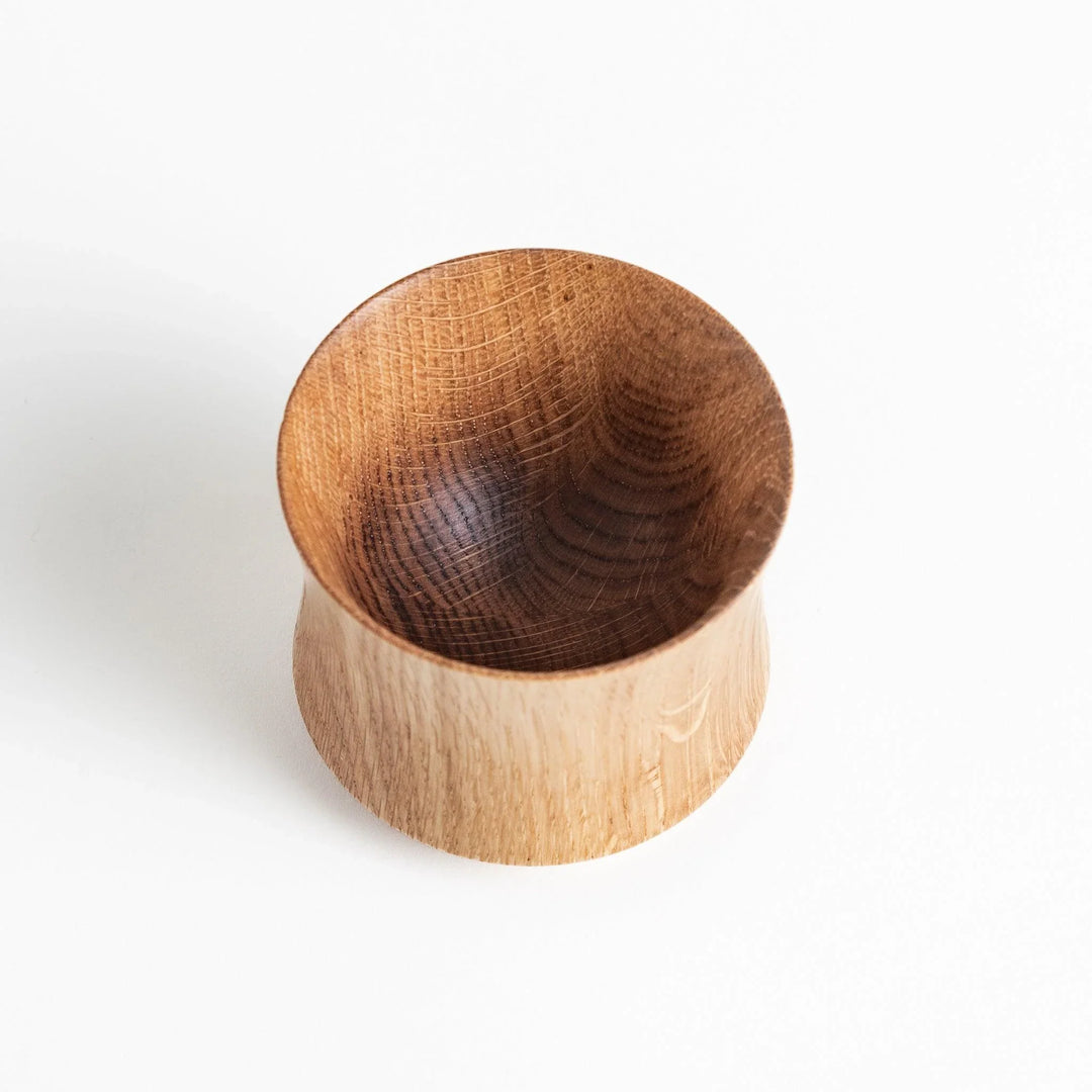 Pair of Mizunara oak whisky cups with smooth curves and rich grain pattern perfect for fine spirits.