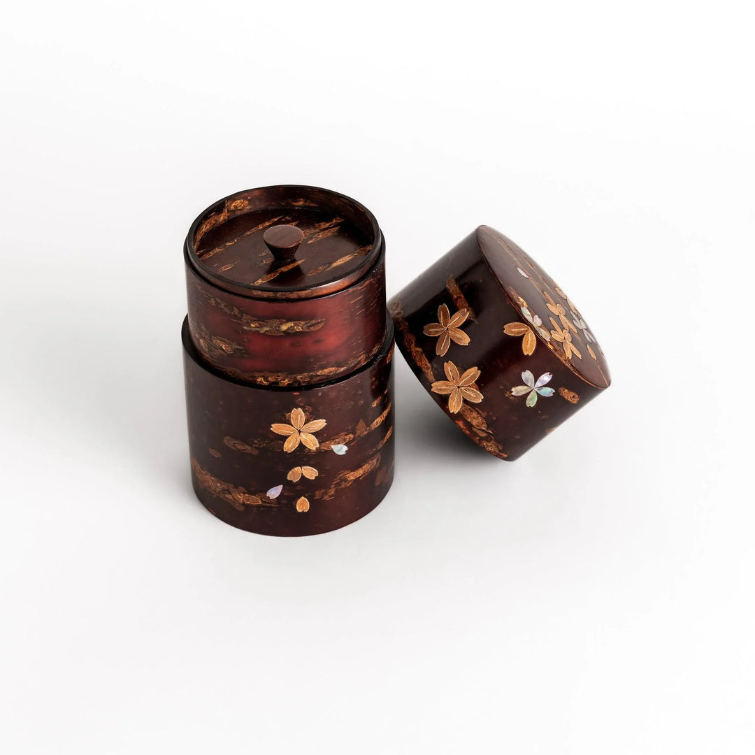 Elegant cherry bark tea caddy with mother-of-pearl cherry blossom inlay, perfect for storing and preserving fine tea leaves.