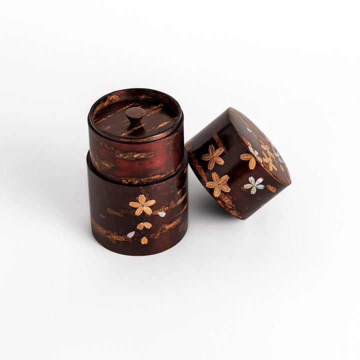 Elegant cherry bark tea caddy with mother-of-pearl cherry blossom inlay, perfect for storing and preserving fine tea leaves.
