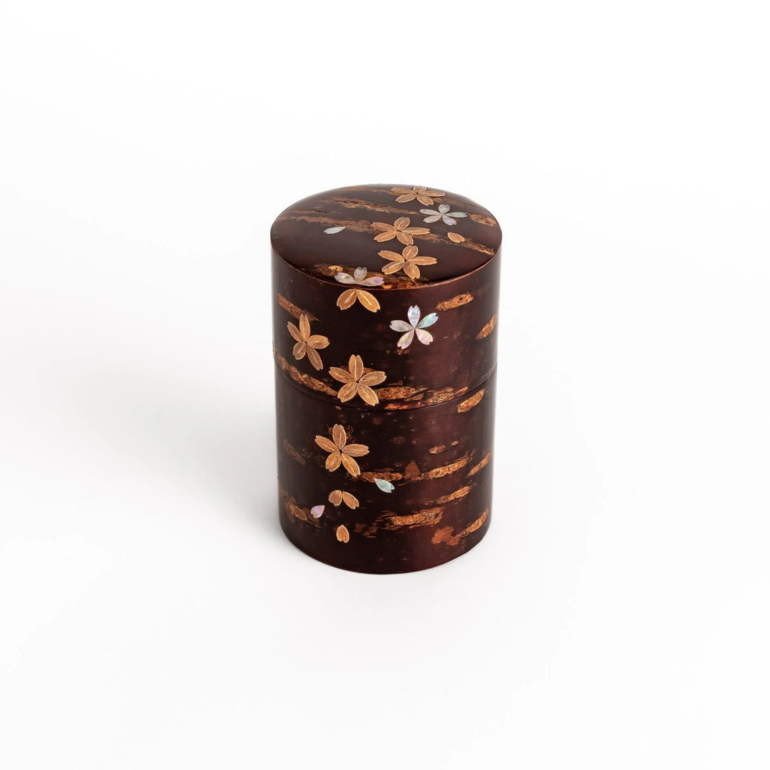 Elegant cherry bark tea caddy with mother-of-pearl cherry blossom inlay, perfect for storing and preserving fine tea leaves.