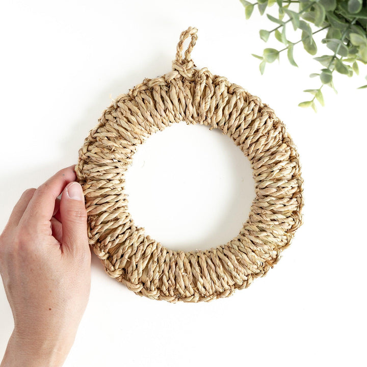 Natural straw trivet with woven pattern ideal for placing hot dishes or pots adding simple stylish touch to kitchen.