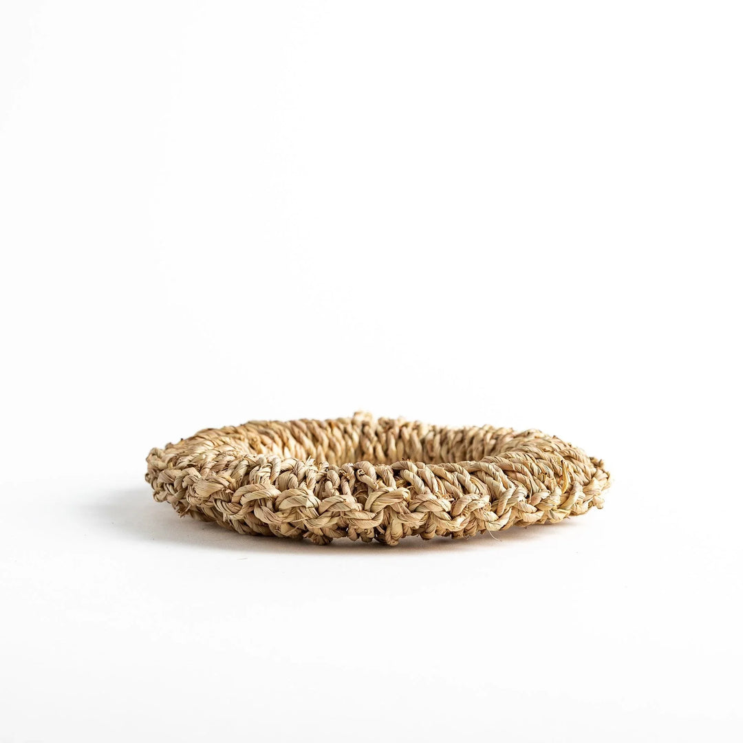 Natural straw trivet with woven pattern ideal for placing hot dishes or pots adding simple stylish touch to kitchen.
