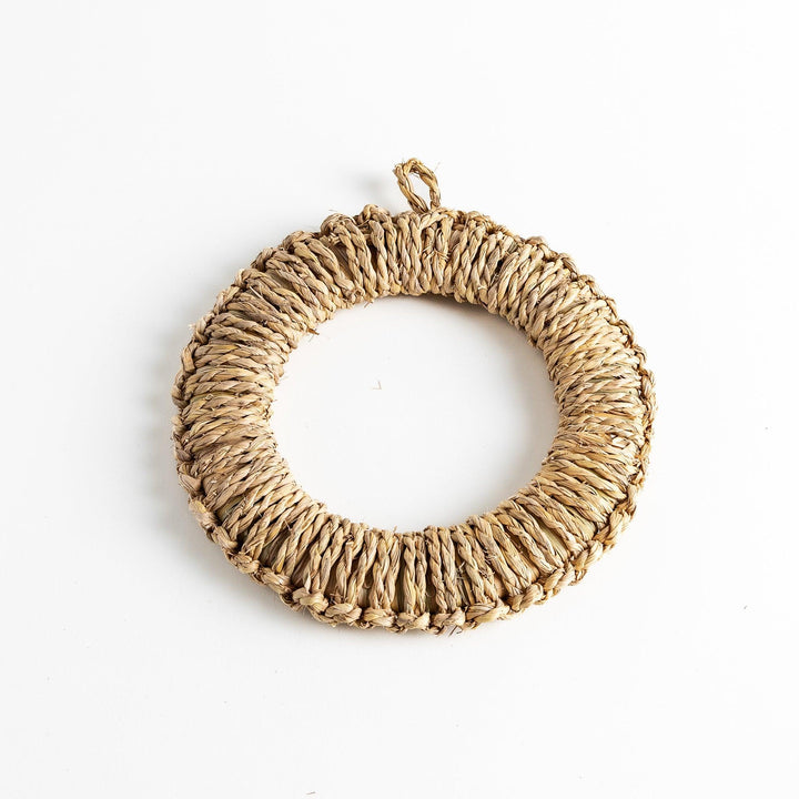 Natural straw trivet with woven pattern ideal for placing hot dishes or pots adding simple stylish touch to kitchen.