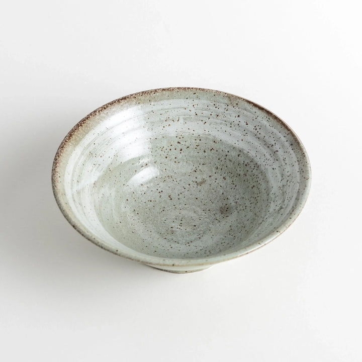 A light gray, wide-rimmed bowl with a textured and speckled surface.