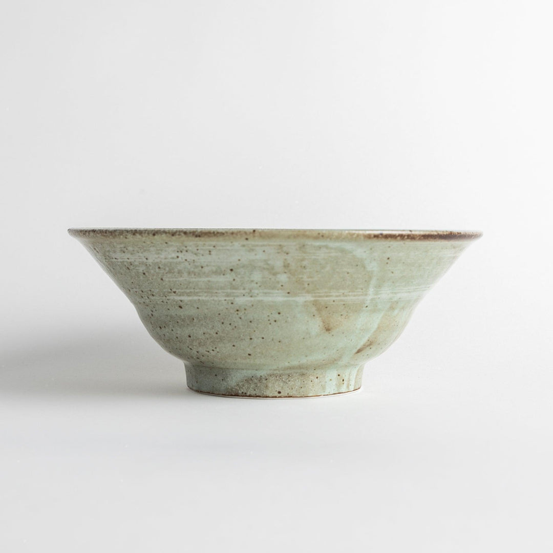 A light gray, wide-rimmed bowl with a textured and speckled surface.