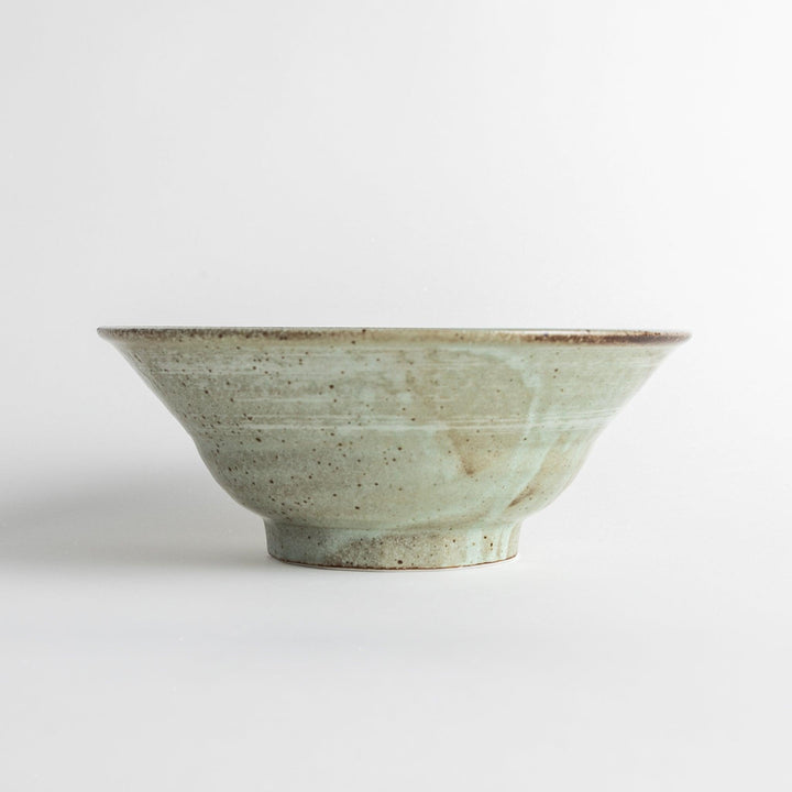 A light gray, wide-rimmed bowl with a textured and speckled surface.