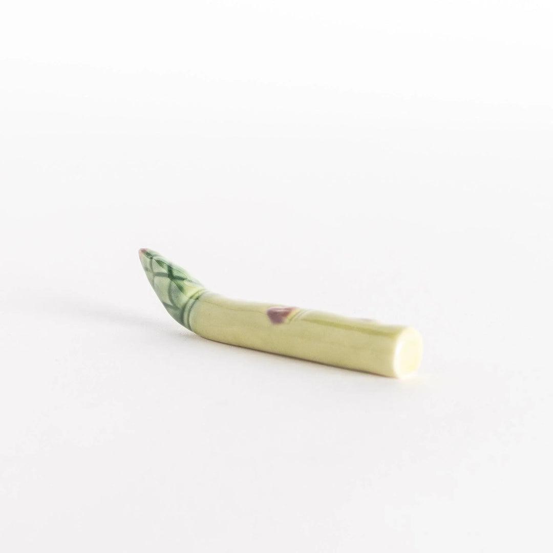 Side view of the ceramic asparagus chopsticks rest, showing its smooth, natural shape.