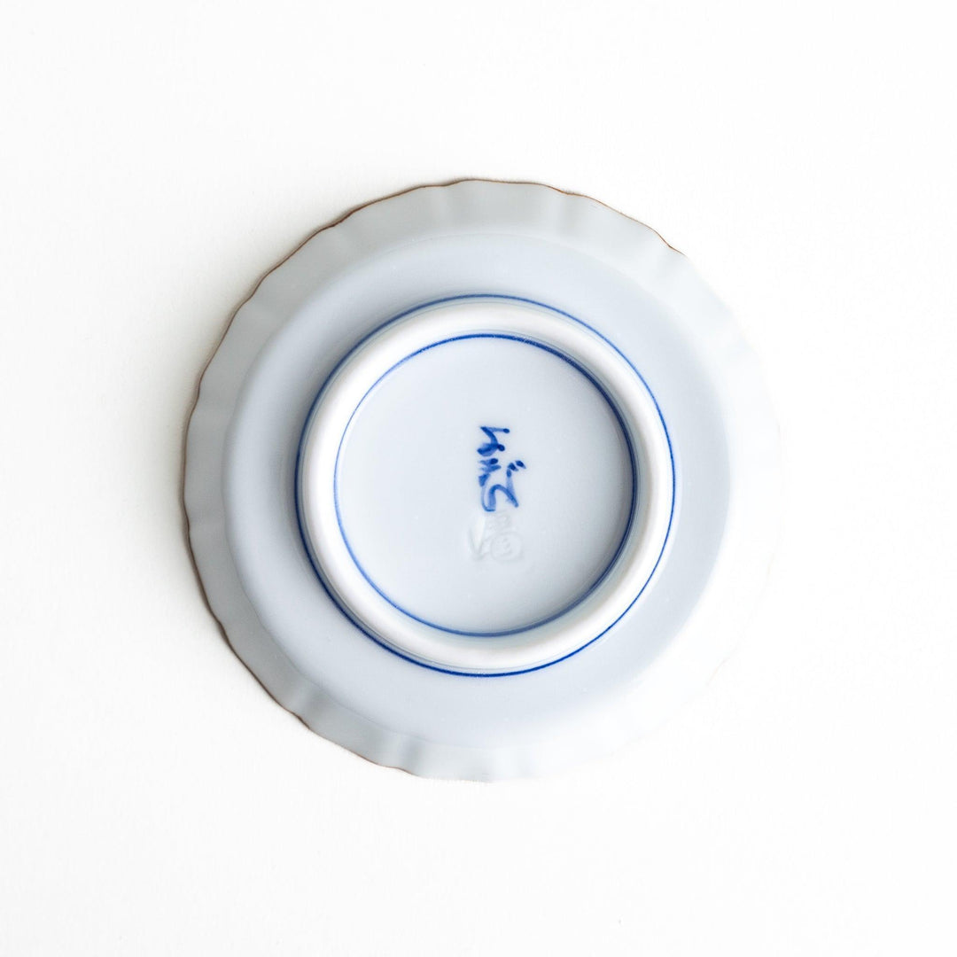 A vibrant ceramic dish with intricate patterns in blue, red, and green, centering around a depiction of Mount Fuji.