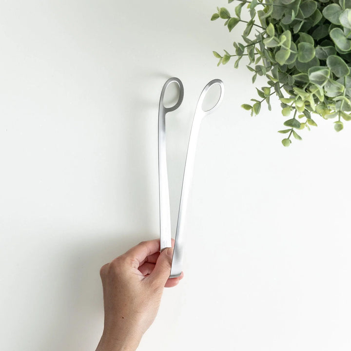 Curved stainless steel tongs with holes at the end for drainage