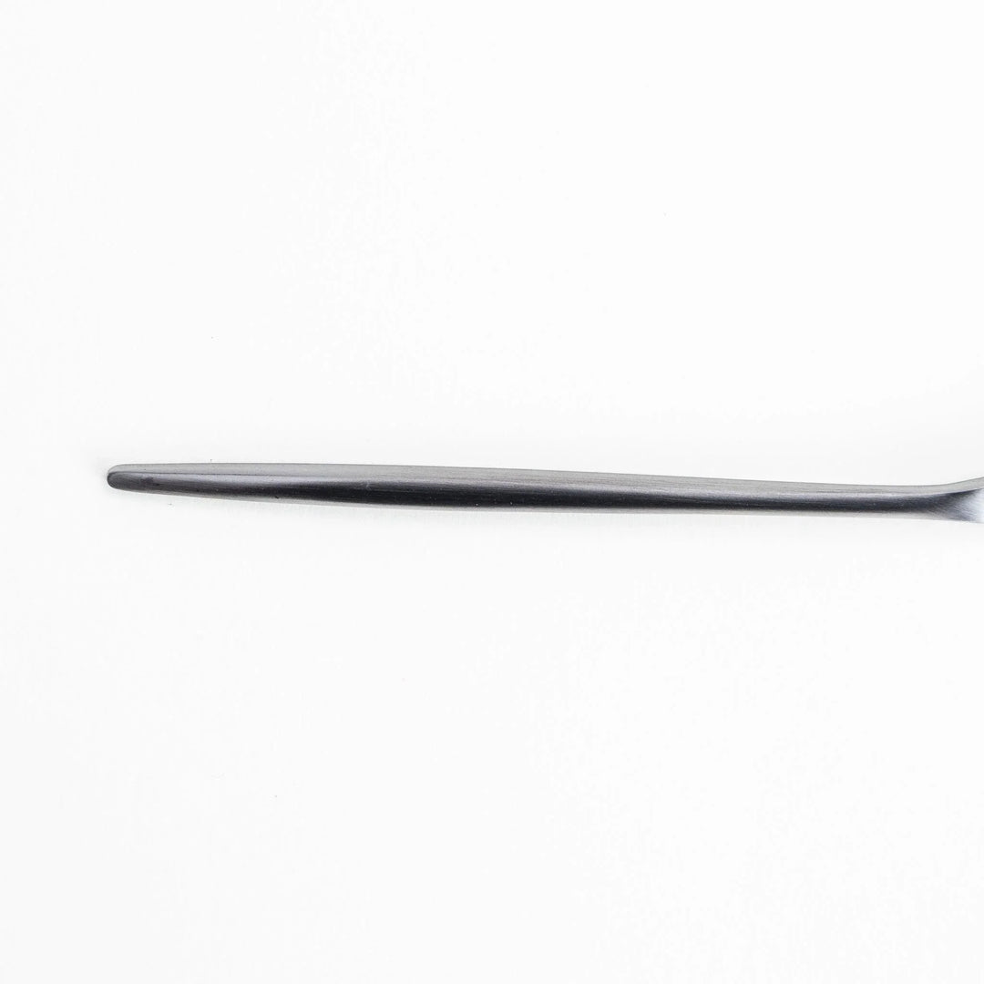 Long-handled stainless steel honey spoon with a uniquely shaped flat scoop