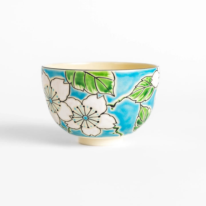 Plum Blossom Matcha Bowl with pink floral designs on a cream surface, adding elegance to your matcha moments.