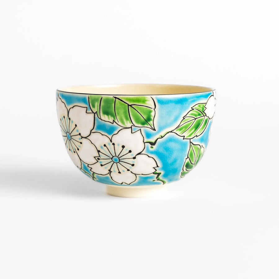 Plum Blossom Matcha Bowl with pink floral designs on a cream surface, adding elegance to your matcha moments.