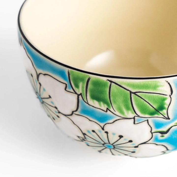 Plum Blossom Matcha Bowl with pink floral designs on a cream surface, adding elegance to your matcha moments.