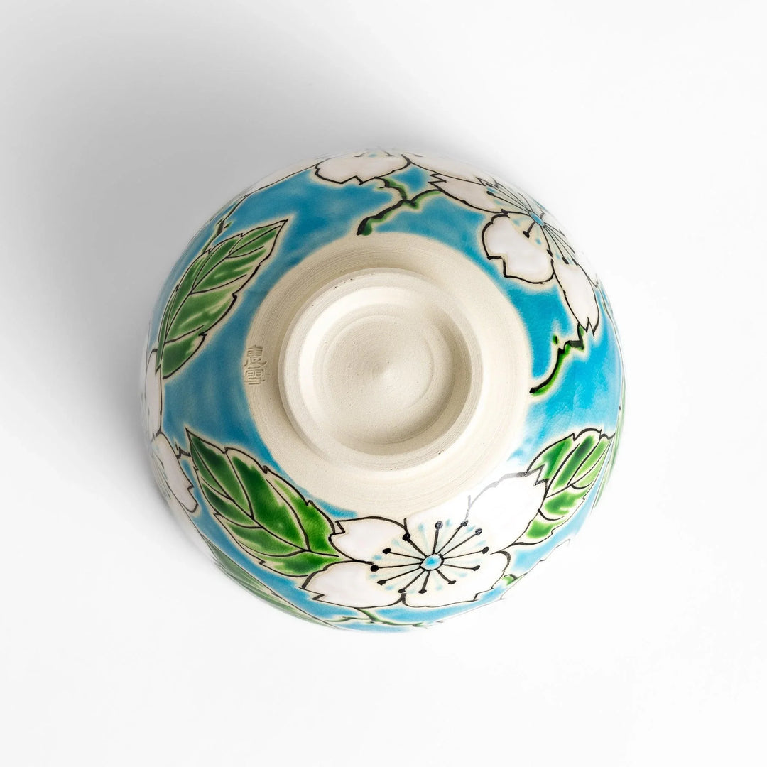 Plum Blossom Matcha Bowl with pink floral designs on a cream surface, adding elegance to your matcha moments.
