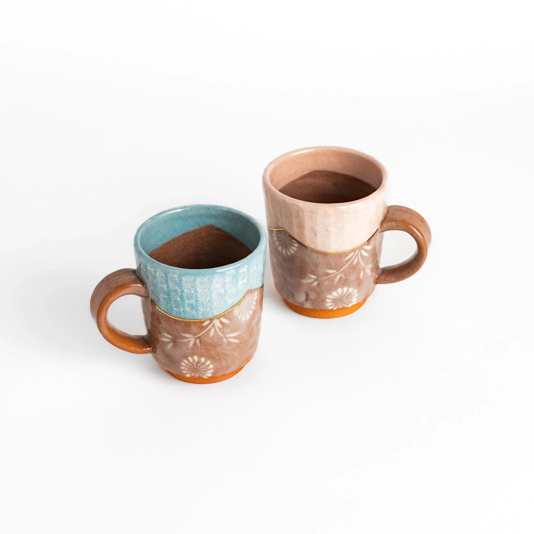 Two floral mugs in pink and blue with gold accents, perfect for enjoying hot drinks in elegant style.
