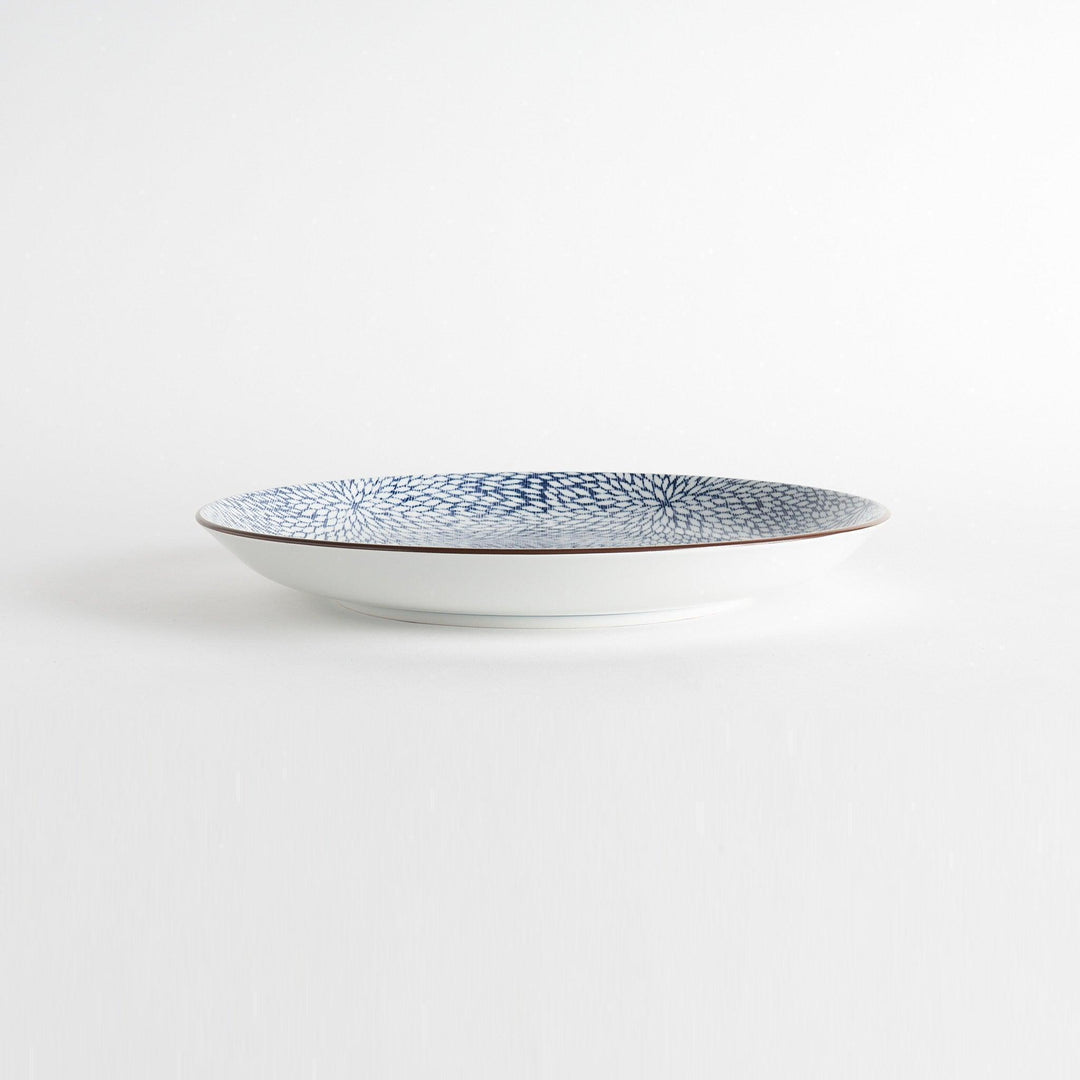 A round serving plate adorned with a detailed pattern of concentric blue dots creating a mesmerizing effect.