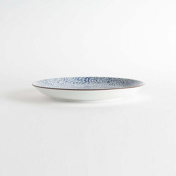 A round serving plate adorned with a detailed pattern of concentric blue dots creating a mesmerizing effect.