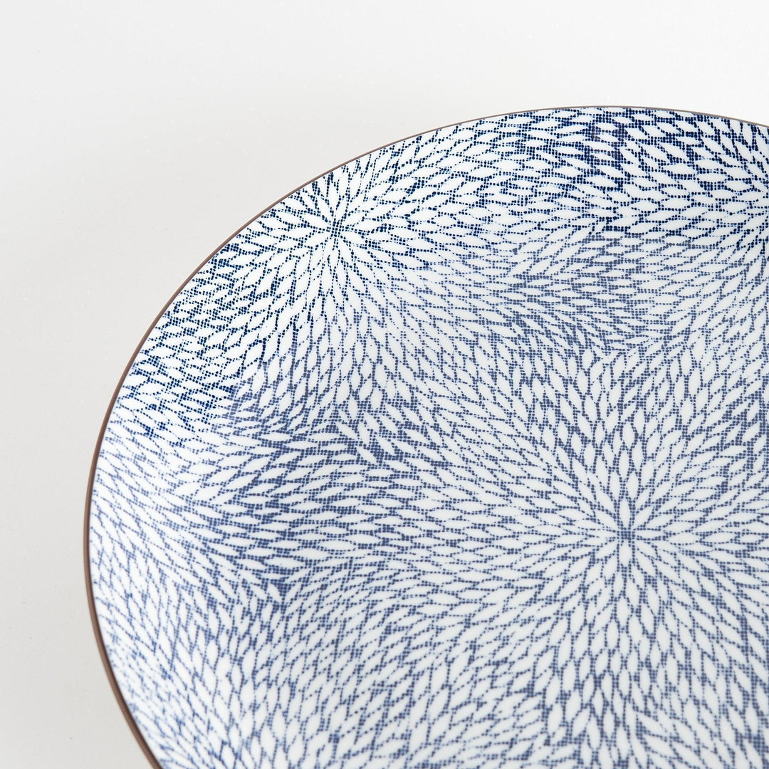 A round serving plate adorned with a detailed pattern of concentric blue dots creating a mesmerizing effect.