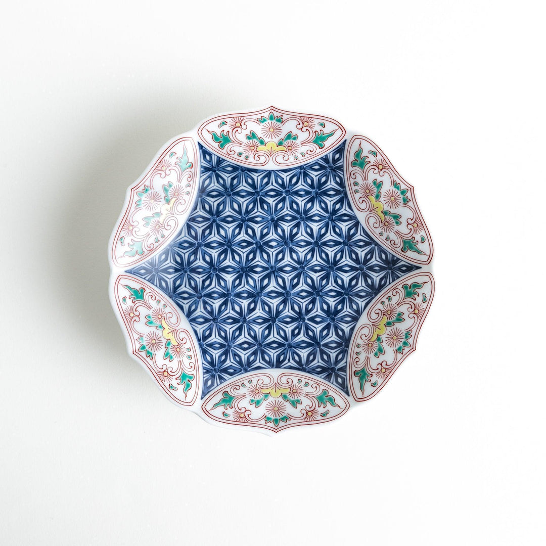 Blue dessert plate with geometric center and ornate floral rim in red green and gold with scalloped edge.