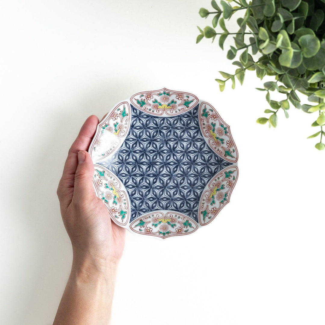 Blue dessert plate with geometric center and ornate floral rim in red green and gold with scalloped edge.