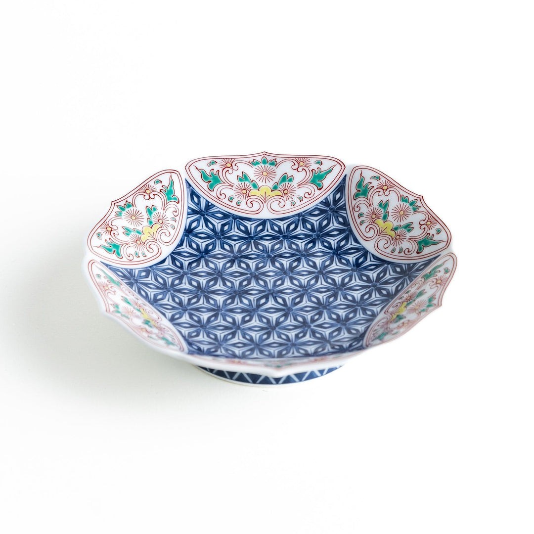 Blue dessert plate with geometric center and ornate floral rim in red green and gold with scalloped edge.