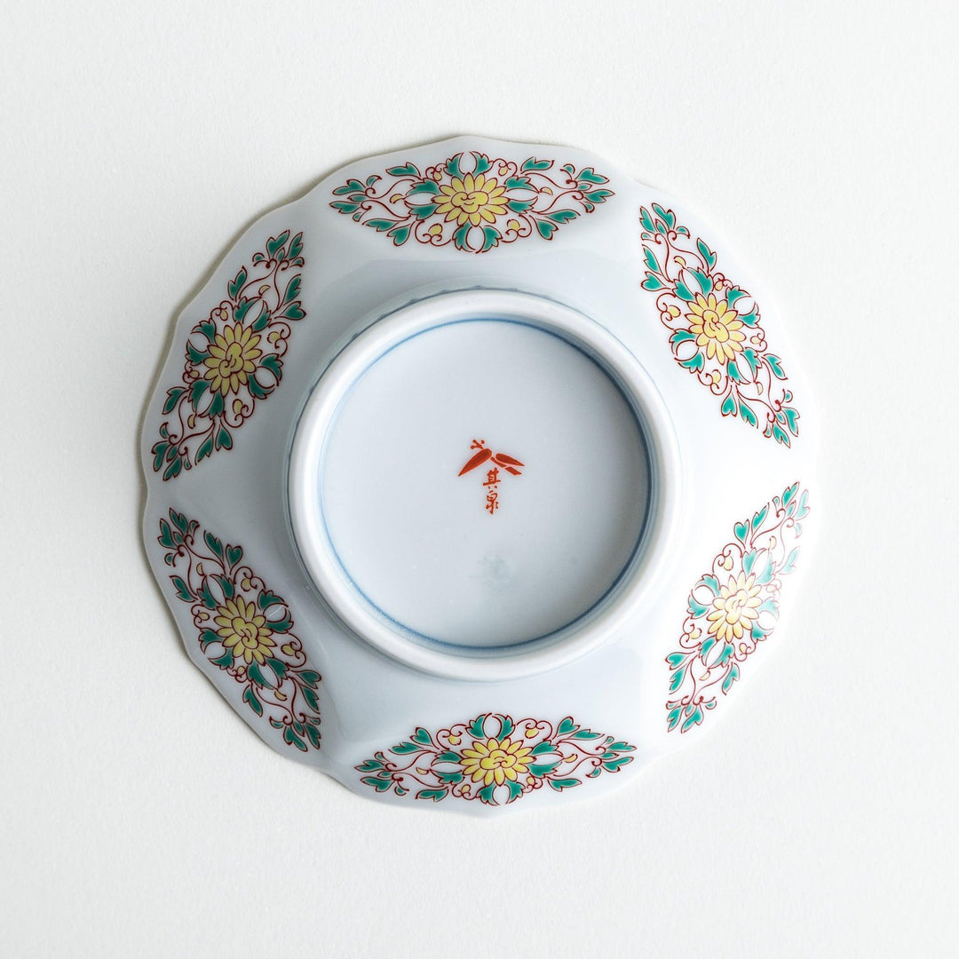 Sauce dish with blue geometric center and ornate floral rim in red green and gold with scalloped edge.