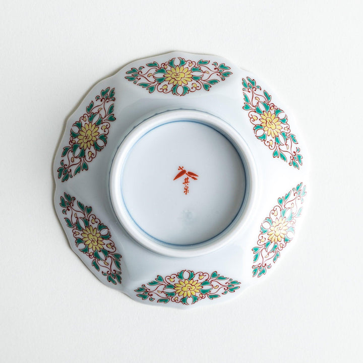 Sauce dish with blue geometric center and ornate floral rim in red green and gold with scalloped edge.