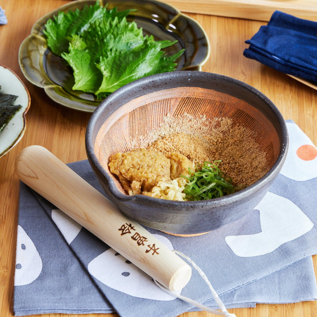 Japanese suribachi mortar with ridged interior and hinoki wood pestle making sesame miso sauce