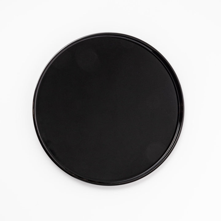 Glossy black Japanese wooden round tray with raised rim for serving tea or displaying tableware elegantly.