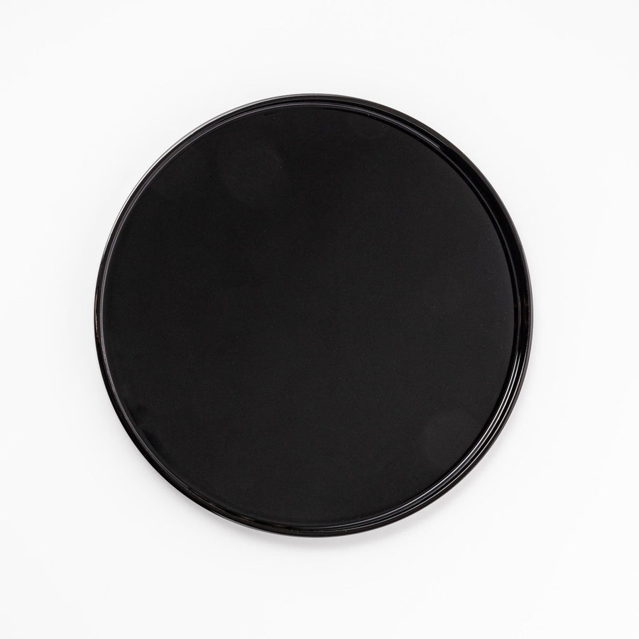 Glossy black Japanese wooden round tray with raised rim for serving tea or displaying tableware elegantly.