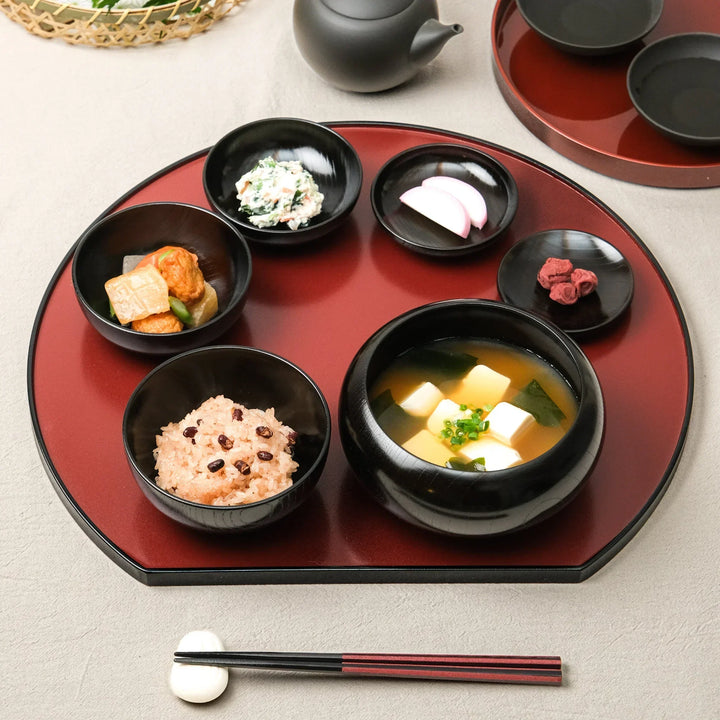 Japanese black lacquered oryoki bowl set with rice, miso soup, and side dishes beautifully arranged on a traditional tray
