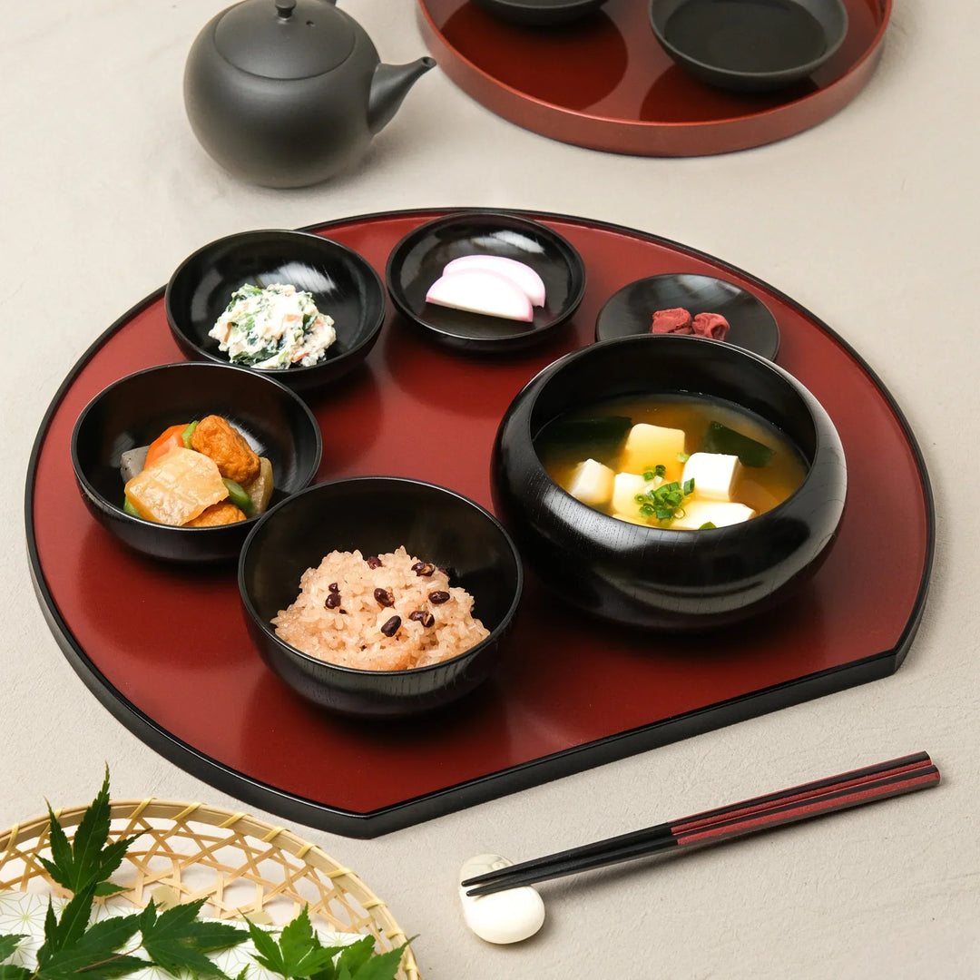 Japanese black lacquered oryoki bowl set with rice, miso soup, and side dishes beautifully arranged on a traditional tray