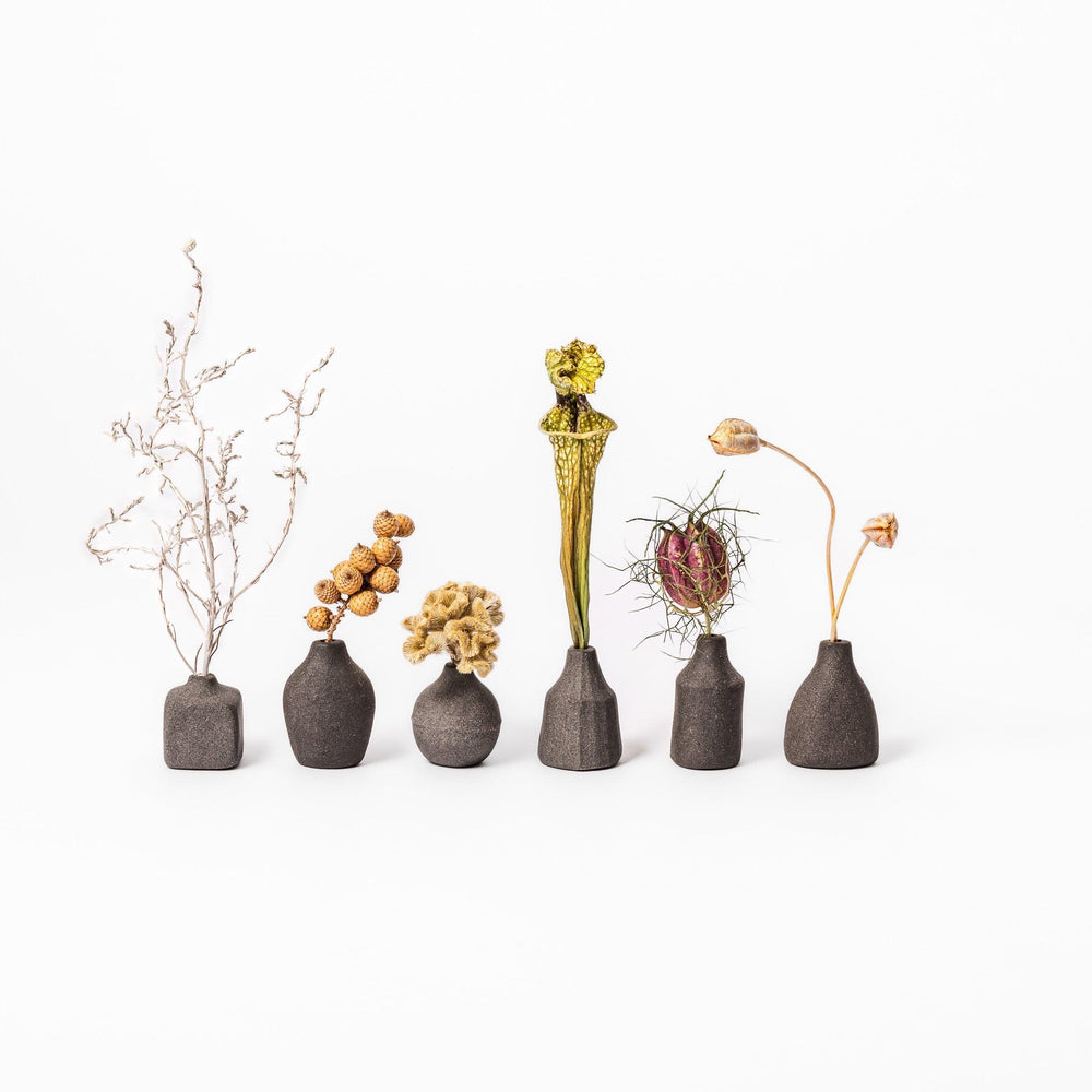 Dark ceramic bud vase with dried flowers, ideal for bringing a modern Japanese touch to any room or table.