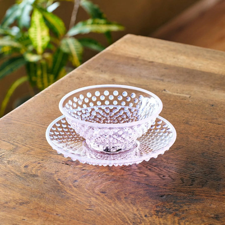 Pink glass dessert bowl and saucer with raised dot texture and starburst base, perfect for elegant sweets or fruit servings.