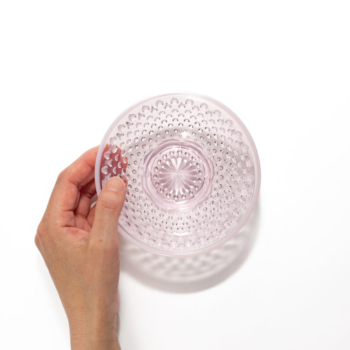 Pink glass dessert bowl and saucer with raised dot texture and starburst base, perfect for elegant sweets or fruit servings.