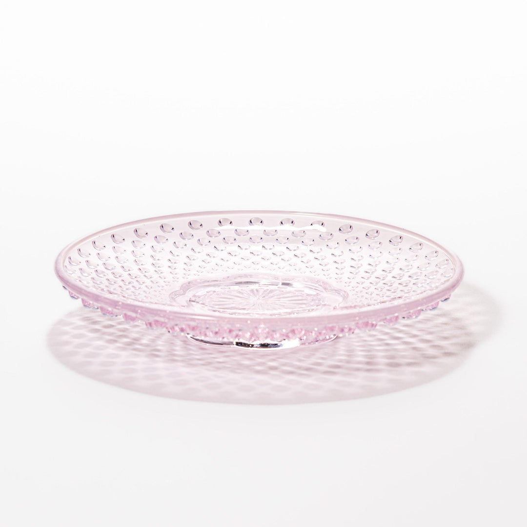 Pink glass dessert bowl and saucer with raised dot texture and starburst base, perfect for elegant sweets or fruit servings.