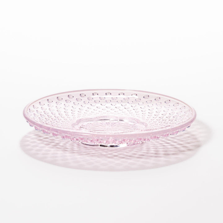 Pink glass dessert bowl and saucer with raised dot texture and starburst base, perfect for elegant sweets or fruit servings.