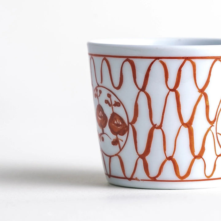 A condiment bowl decorated with a round floral motif, surrounded by a wavy lattice pattern, available in blue or red ink.