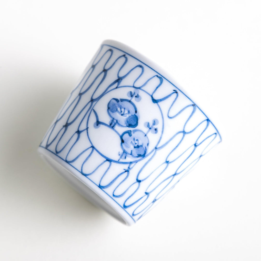 A condiment bowl decorated with a round floral motif, surrounded by a wavy lattice pattern, available in blue or red ink.