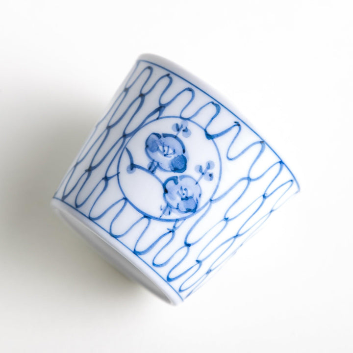 A condiment bowl decorated with a round floral motif, surrounded by a wavy lattice pattern, available in blue or red ink.