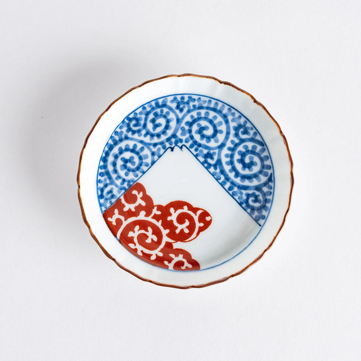 Raised rim Japanese sauce dish with blue spirals red clouds and Mount Fuji motif blending tradition and art.