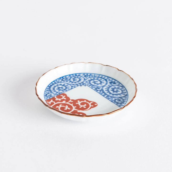 Raised rim Japanese sauce dish with blue spirals red clouds and Mount Fuji motif blending tradition and art.