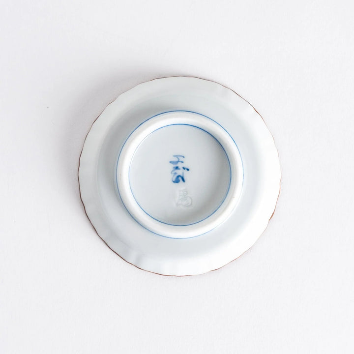 Raised rim Japanese sauce dish with blue spirals red clouds and Mount Fuji motif blending tradition and art.