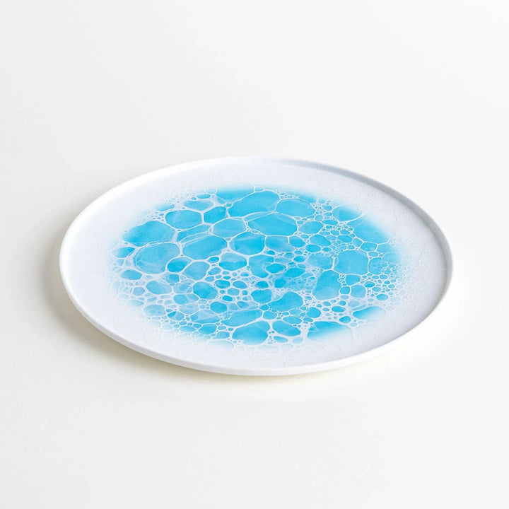 Diagonal angle of the Bubble Dinner Plate, capturing the plate’s elegant form and vibrant blue bubble design.