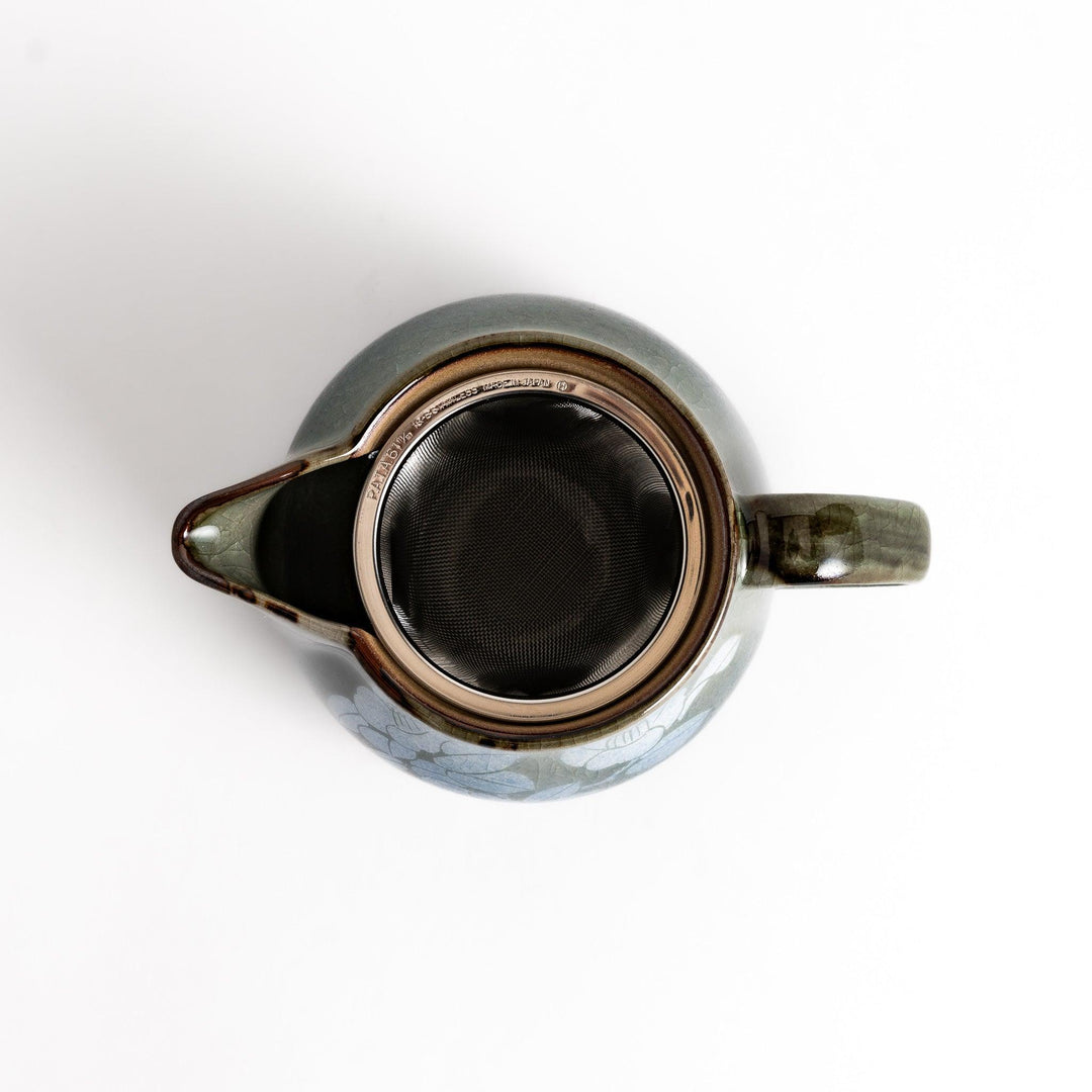 Stylish blue ceramic teapot with a delicate white camellia flower pattern. Perfect for enjoying your favorite tea.