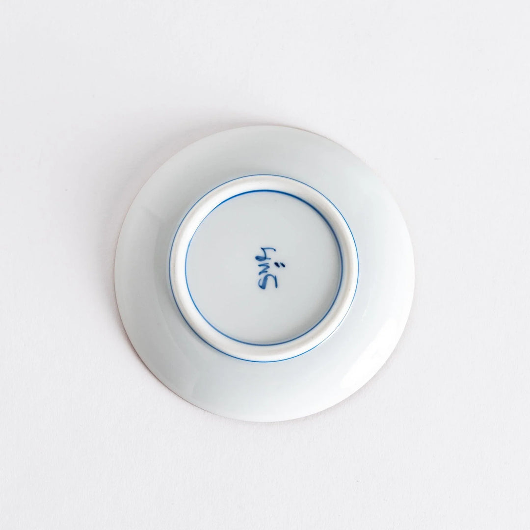 Bottom view of a sauce dish with a maker's mark, highlighting its smooth finish and quality craftsmanship.