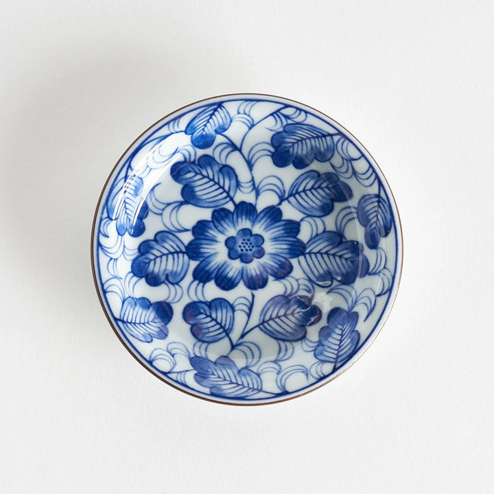 A round saucer featuring a delicate blue floral design on a white background.